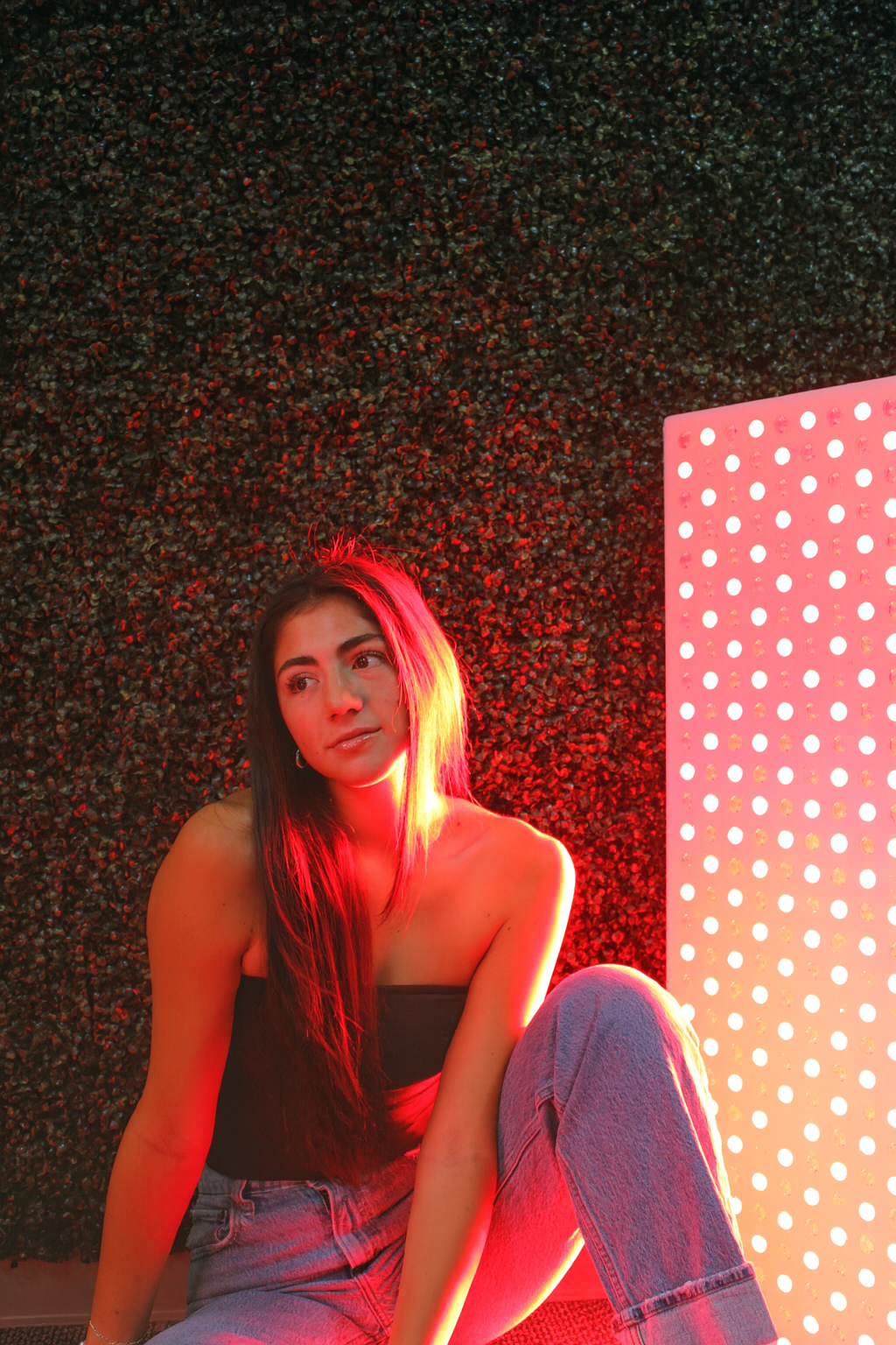 Women sitting in front of a red light panel