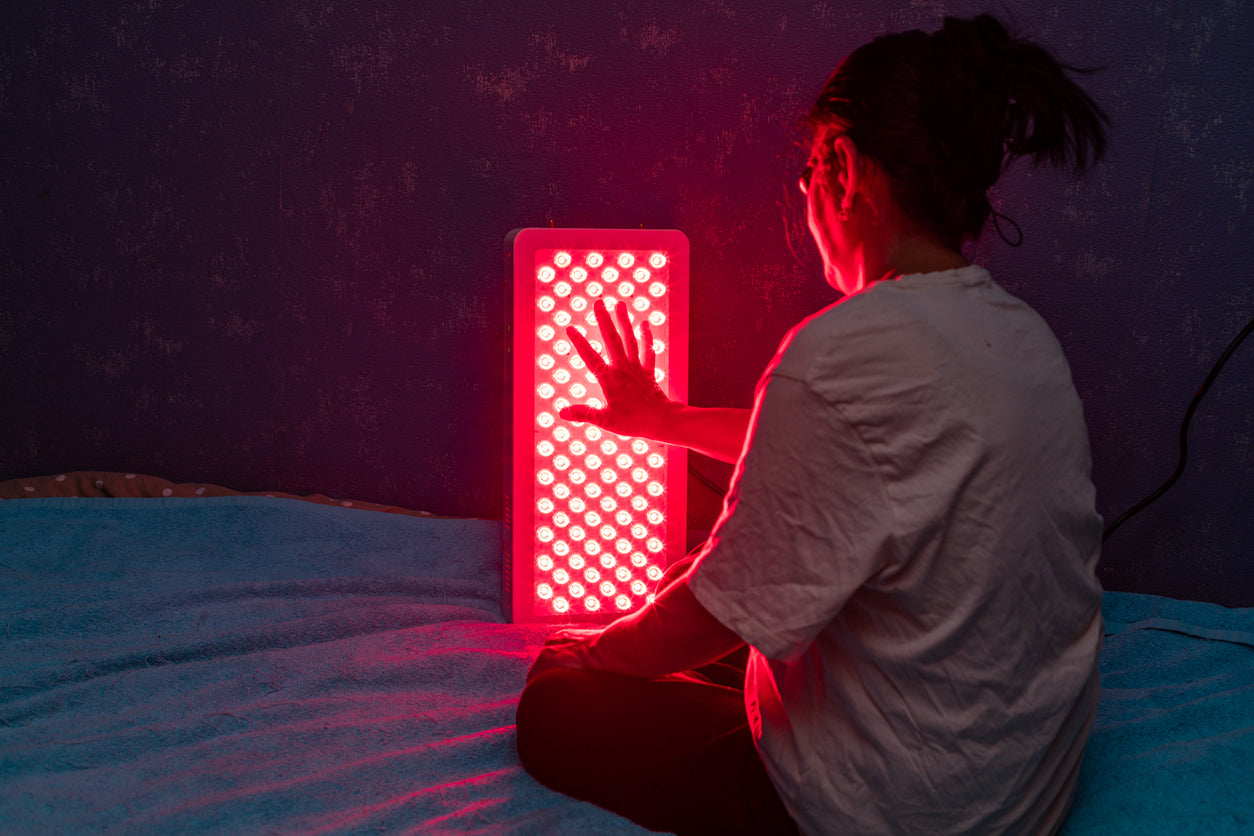 Man sitting in front of red light panel