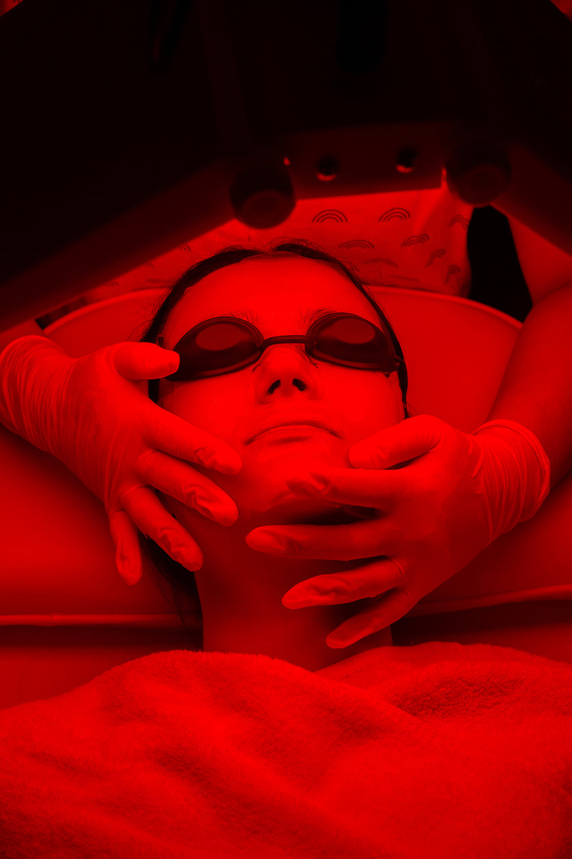 Woman laying under a red light for for health improvement